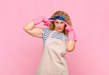 Ciddi ve konsantre görünümlü orta yaşlı bir kadın. Zorlu bir ev hanımı konsepti hakkında beyin fırtınası yapıyor ve düşünüyor.