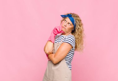 Orta yaşlı bir kadın, yoğun bakışlı, şüpheli bir ifadeyle merak eden, yukarı bakan ve yan hizmetçi konsepti