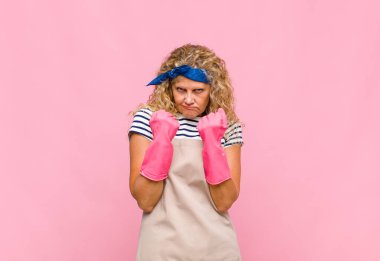 Orta yaşlı kadın kendinden emin, sinirli, güçlü ve agresif görünüyor. Yumrukları boks pozisyonunda dövüşmeye hazır. Hizmetçi konsepti.