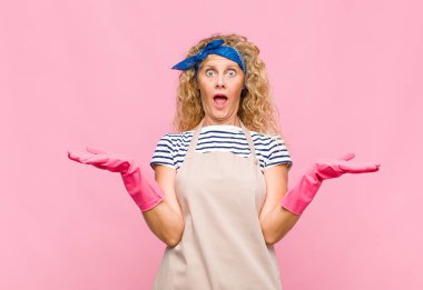 middle age woman shrugging with a dumb, crazy, confused, puzzled expression, feeling annoyed and clueless housekeeper concept