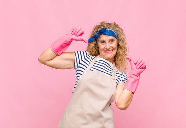 Orta yaşlı bir kadın gururlu, kibirli ve kendinden emin, tatmin olmuş ve başarılı görünüyor, ev hanımı kavramına işaret ediyor.