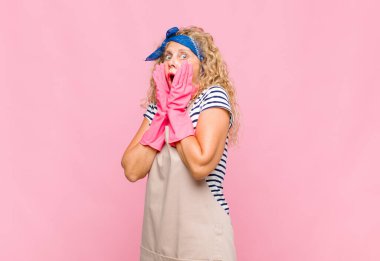 Orta yaşlı bir kadın mutlu, heyecanlı ve şaşırmış hissediyor. İki elini de yüz temizleyicisi konseptine koyuyor.