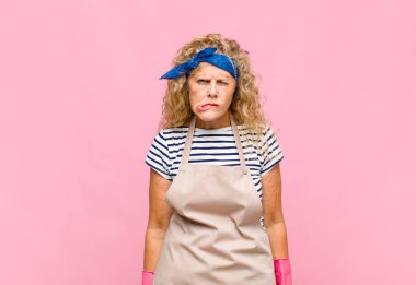 Orta yaşlı bir kadın hangi seçeneği seçeceği konusunda bilgisiz, kafası karışık ve kararsız hissediyor, sorunlu ev kadını kavramını çözmeye çalışıyor.