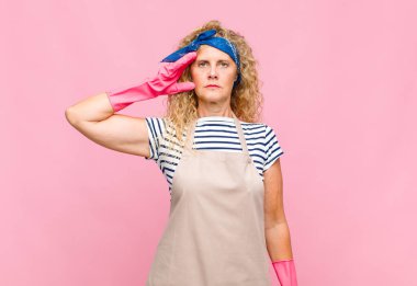 Orta yaşlı bir kadın kameraya askeri selamlama yapıyor. Onur ve vatanseverlik göstergesi olarak. Hizmetçi konseptine saygı gösteriyor.