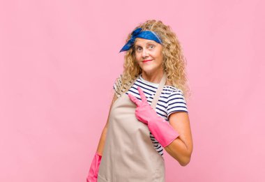 Orta yaşlı bir kadın kendini mutlu, pozitif ve başarılı hisseder. Göğüs üzerinde el yapımı V şekli, zafer ya da huzur içinde yaşayan hizmetçi kavramı.