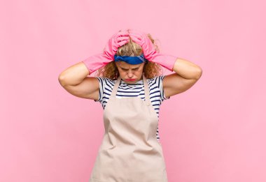 Orta yaşlı bir kadın kendini stresli ve hayal kırıklığına uğramış hissediyor. Yumruk yumruğa, yorgun, mutsuz ve migren hastası bir ev hanımı gibi hissediyor.