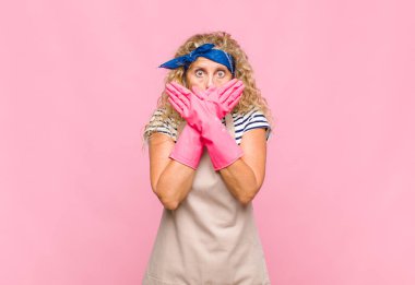 Orta yaşlı bir kadın şok olmuş, şaşırmış bir ifadeyle ağzını kapatıyor. Sır saklıyor ya da hizmetçi konsepti diyor.