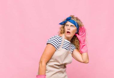 Orta yaşlı bir kadın ciddi ve meraklı görünüyor, dinliyor, gizli bir konuşma ya da dedikodu duymaya çalışıyor, hizmetçi konseptini dinliyor.