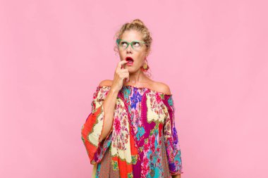 Şaşırmış, gergin, endişeli ya da korkmuş bakışları olan orta yaşlı bir kadın fotokopi alanına doğru bakıyor.