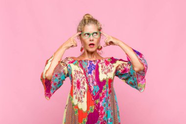 Orta yaşlı bir kadın kafası karışık ya da şüpheci, bir fikre odaklanmış, çok düşünüyor, kenarda boşluklar arıyor.