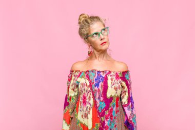 Endişeli, kafası karışık, budala bir ifadeyle orta yaşlı kadın, kopya alanı arıyor, şüphe ediyor.