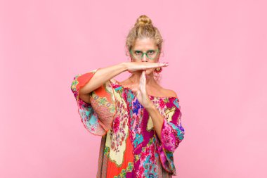 Orta yaşlı bir kadın ciddi, sert, kızgın ve canı sıkkın görünüyor.