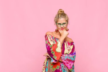 Orta yaşlı kadın gülümsüyor, hayattan zevk alıyor, mutlu, arkadaş canlısı, tatmin olmuş ve tasasız.