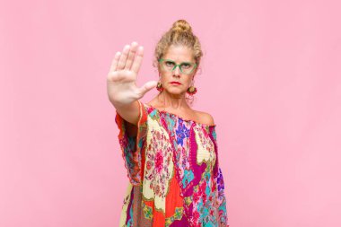 Orta yaşlı bir kadın ciddi, sert, hoşnutsuz ve kızgın görünüyor.