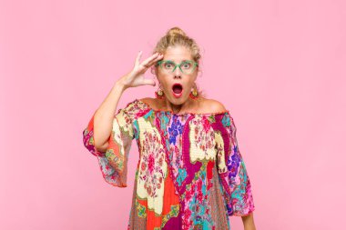 Orta yaşlı kadın mutlu, şaşkın ve şaşırmış görünüyor, gülümsüyor ve inanılmaz ve inanılmaz iyi haberleri fark ediyor.