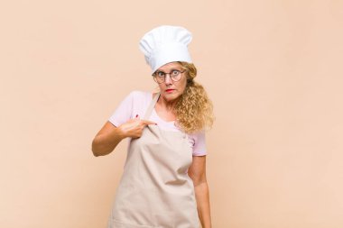 Orta yaşlı fırıncı kendini şaşkın, şaşkın ve güvensiz hissediyor. Kendini gösterip kim olduğunu soruyor, ben mi??