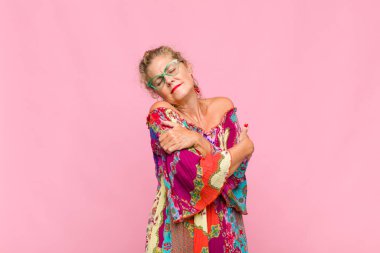 Orta yaşlı bir kadın aşık oluyor, gülümsüyor, sarılıyor ve kendine sarılıyor, bekar kalıyor, bencil ve benmerkezci oluyor.