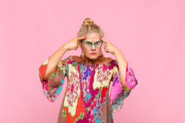 Ciddi ve konsantre görünümlü orta yaşlı bir kadın, beyin fırtınası yapıyor ve zorlu bir sorunu düşünüyor.