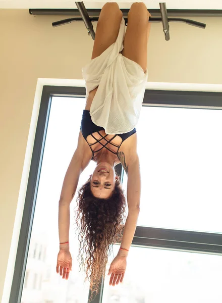 Evde yoga yapan genç ve güzel bir kadın. Evde dinlenme ve antrenman.