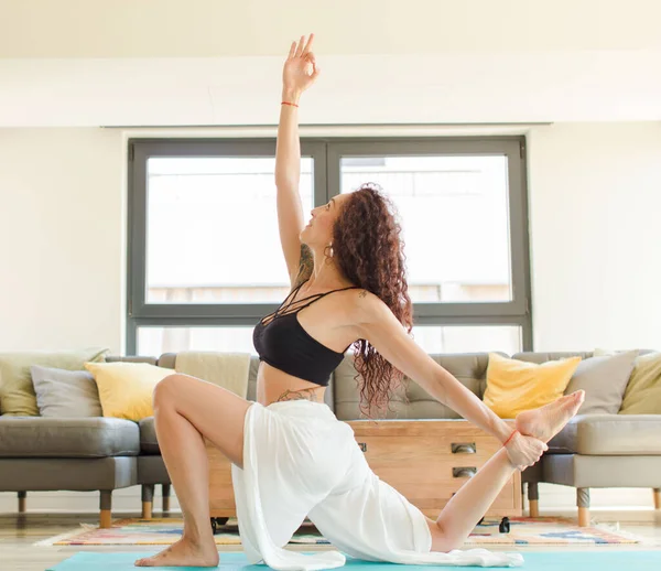 Evde yoga yapan genç ve güzel bir kadın. Evde dinlenme ve antrenman.