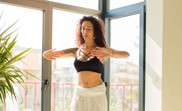 Evde yoga yapan genç ve güzel bir kadın. Evde dinlenme ve antrenman.