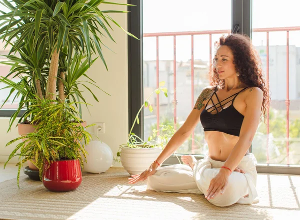 Evde yoga yapan genç ve güzel bir kadın. Evde dinlenme ve antrenman.