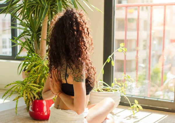 Evde yoga yapan genç ve güzel bir kadın. Evde dinlenme ve antrenman.