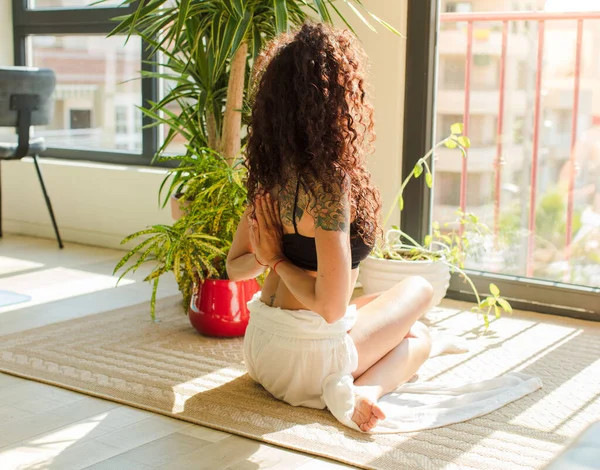 Evde yoga yapan genç ve güzel bir kadın. Evde dinlenme ve antrenman.