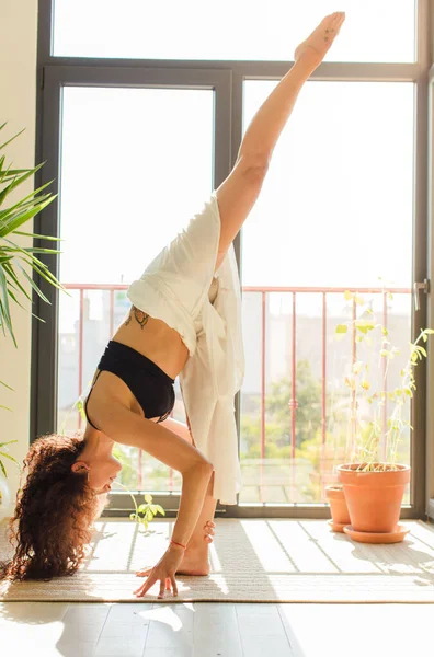 Evde yoga yapan genç ve güzel bir kadın. Evde dinlenme ve antrenman.