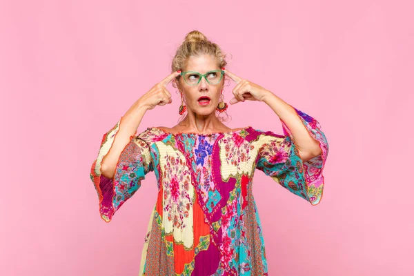 Orta yaşlı bir kadın kafası karışık ya da şüpheci, bir fikre odaklanmış, çok düşünüyor, kenarda boşluklar arıyor.