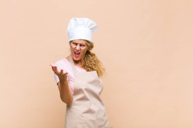 Orta yaşlı fırıncı kızgın, sinirli ve sinirli görünüyor. Senin neyin var böyle? 