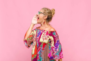 Orta yaşlı kadın profili, mutlu ve heyecanlı görünüyor, bağırıyor ve kenarda yer kopyalamak için arıyor.