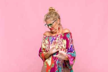 Orta yaşlı bir kadın tiksinmiş ve midesi bulanıyor. İğrenç, kokuşmuş ya da kokuşmuş bir şeyden kaçıyor.