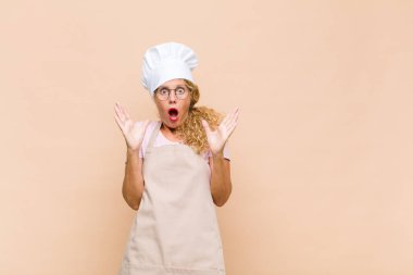 Orta yaşlı fırıncı şaşkın ve şaşkın bir görünüm sergiliyor. İnanılmaz bir şey fark ettiğinde ağzı açık kalıyor.