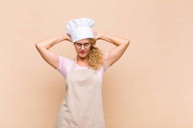 Orta yaşlı fırıncı kendini stresli, endişeli ya da korkmuş hisseder. Elleri başının üstünde, hata yaptığında paniğe kapılır.