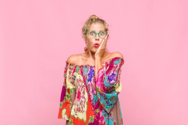 Orta yaşlı bir kadın ağzı açık bir şekilde yüz yüze inanmayarak şok olmuş ve hayrete düşmüş hissediyor.