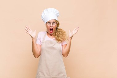 Orta yaşlı bir fırıncı mutlu, heyecanlı, şaşırmış ya da şok olmuş, gülümseyen ve hayretler içinde kalmış.