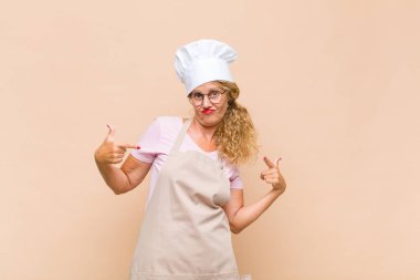 Orta yaşlı fırıncı gururlu, kibirli, mutlu, şaşırmış ve tatmin olmuş görünüyor, kendini gösteriyor, kendini kazanan gibi hissediyor.