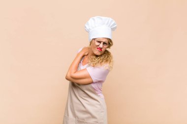 Orta yaşlı kadın fırıncı yorgun, stresli, endişeli, hayal kırıklığına uğramış ve depresyonda, sırtı ya da boynu ağrıyan