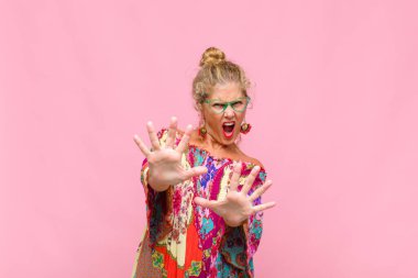 Orta yaşlı bir kadın korku ve panik içinde geri çekilip çığlık atıyor ve kabusa tepki veriyor.