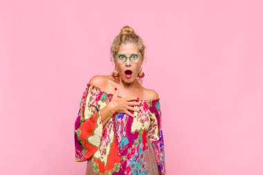 Orta yaşlı kadın şaşkın, şaşkın ve şaşırmış hissediyor, elleri göğsünde ve ağzı açık, kim olduğunu söylüyor, ben mi??