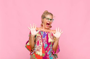 Orta yaşlı bir kadın sersemlemiş ve korkmuş hissediyor. Korkutucu bir şeyden korkuyor. Elleri açık ve uzak durun diyor.