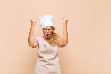 Orta yaşlı bir fırıncı inanılmaz bir başarıyı kutluyor. Kazanan gibi. Heyecanlı ve mutlu görünüyor.!