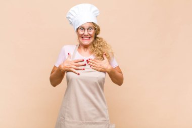 Orta yaşlı fırıncı, mutlu, şaşkın, gururlu ve heyecanlı görünüyor.