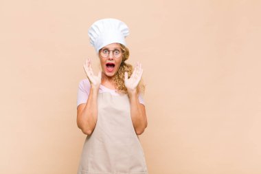 Orta yaşlı bir fırıncı beklenmedik bir sürprizden dolayı şaşkın ve heyecanlı, gülen, şaşkın ve mutlu hisseder.