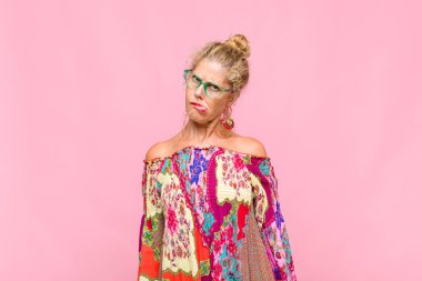 Orta yaşlı kadın şaşkın ve şaşkın görünüyor. Sinirli bir hareketle dudağını ısırıyor. Sorunun cevabını bilmiyor.