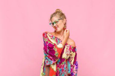 Orta yaşlı bir kadın stresli, hayal kırıklığına uğramış ve yorgun, endişeli ve sorunlu bir bakışla boynunu ovalıyor.