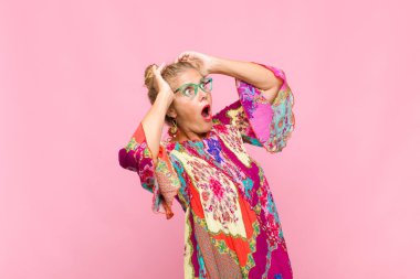 Orta yaşlı, ağzı açık bir kadın korkunç ve şok olmuş görünüyor. Korkunç bir hata yüzünden, el ele tutuşuyor.