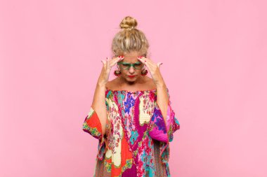 Stresli ve hayal kırıklığına uğramış görünen orta yaşlı bir kadın, baskı altında çalışıyor, başı ağrıyor ve sorunları var.