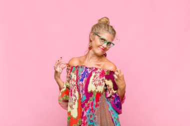 Orta yaşlı bir kadın kibirli, başarılı, pozitif ve gururlu görünüyor.